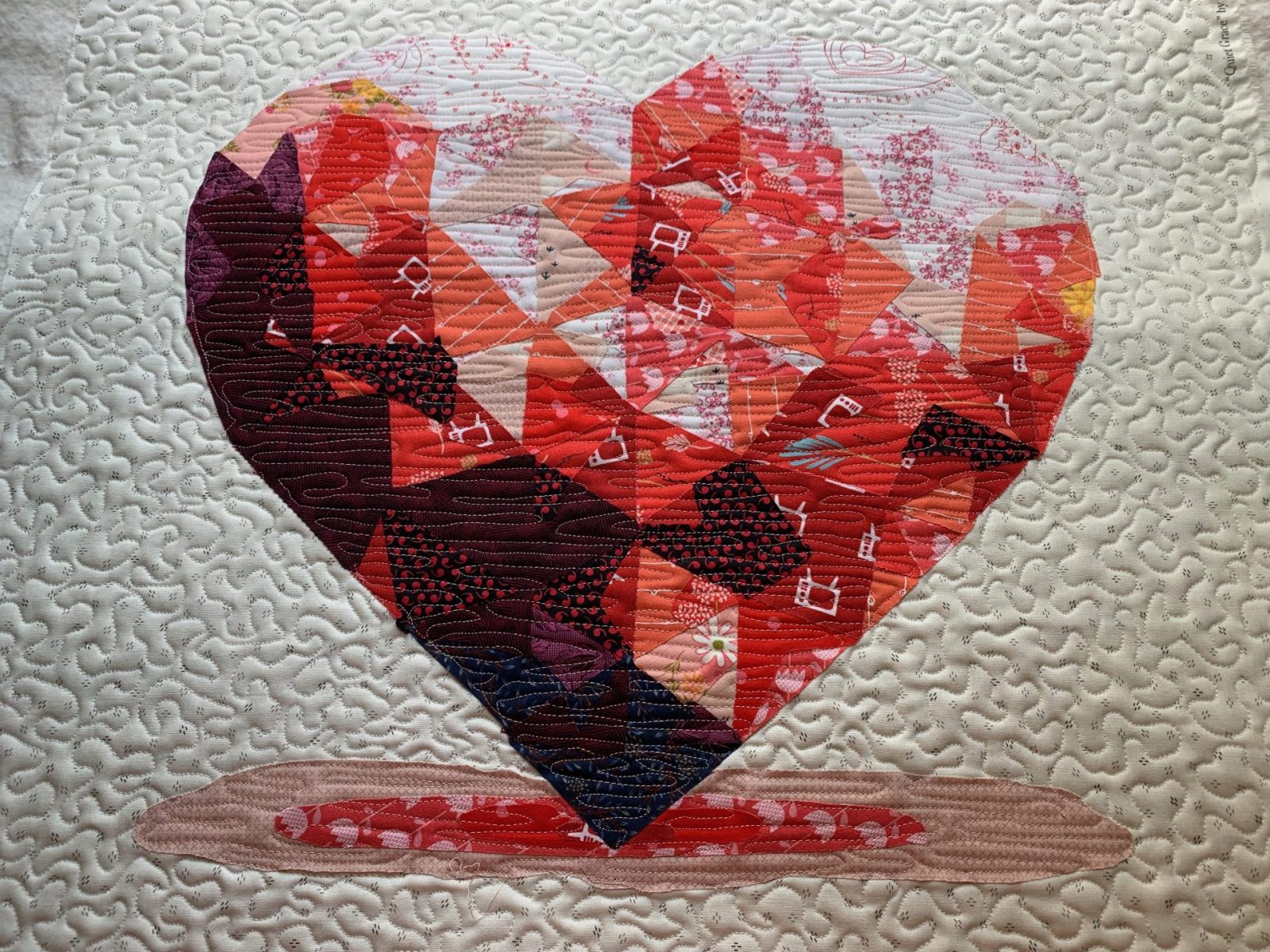 AI-inspired geometric heart quilt block in bold colors by The AI Quilter.