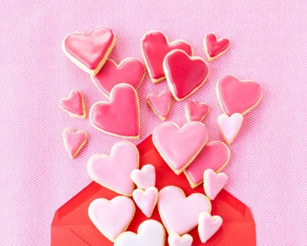 Little cookie hearts with pink icing on a pink background
